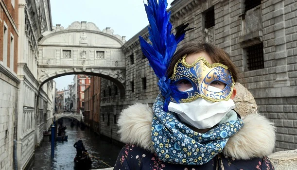 Ung kvinne med munnbind foran sukkenes bro i Venezia